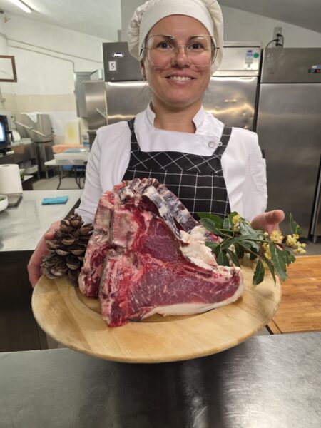 chef susy nella cucina di villa maya che presenta le bistecche da cuocere 