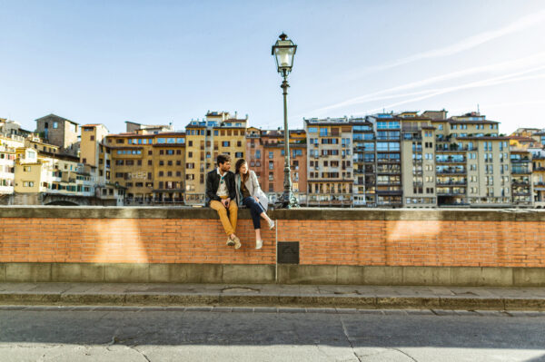 A couple of tourists visiting Florence, in Italy, during a warm and sunny summer day. The guidebook is a stunt copy.