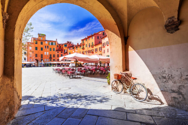 Lucca, Italy - View of Piazza dell'Anfiteatro square through the arch, ancient Roman Empire amphitheater, famous Tuscany.